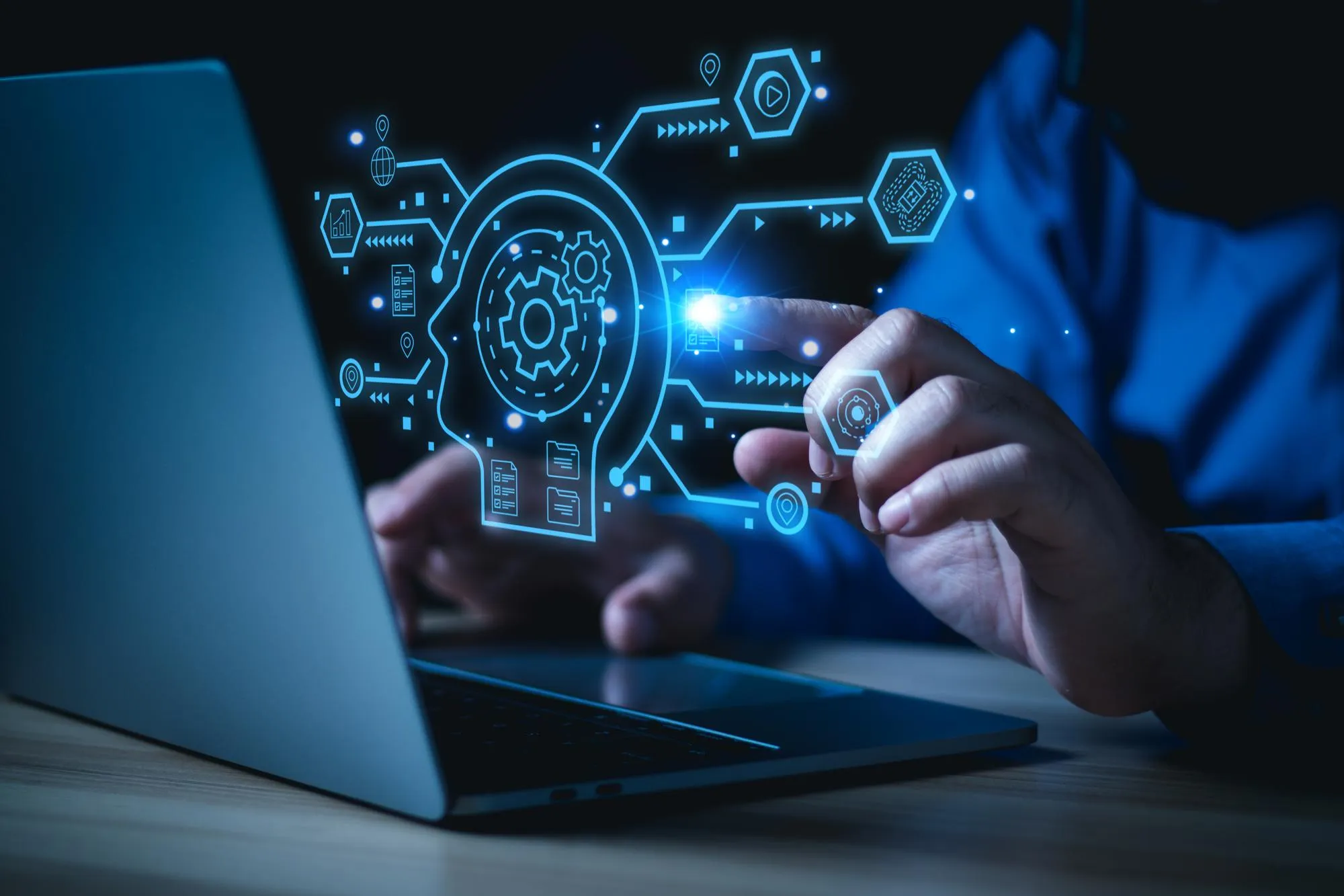 Hands on a laptop with a glowing technology interface overlay