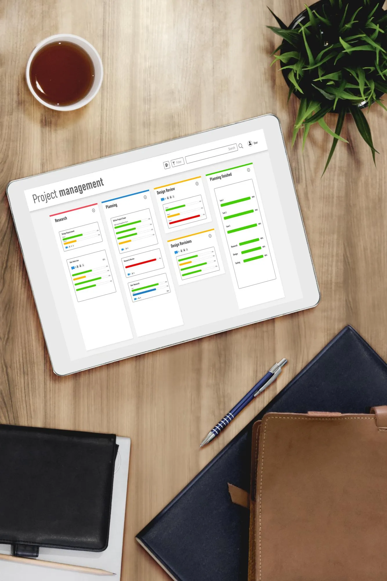 Tablet showing a project management timeline on a wooden desk
