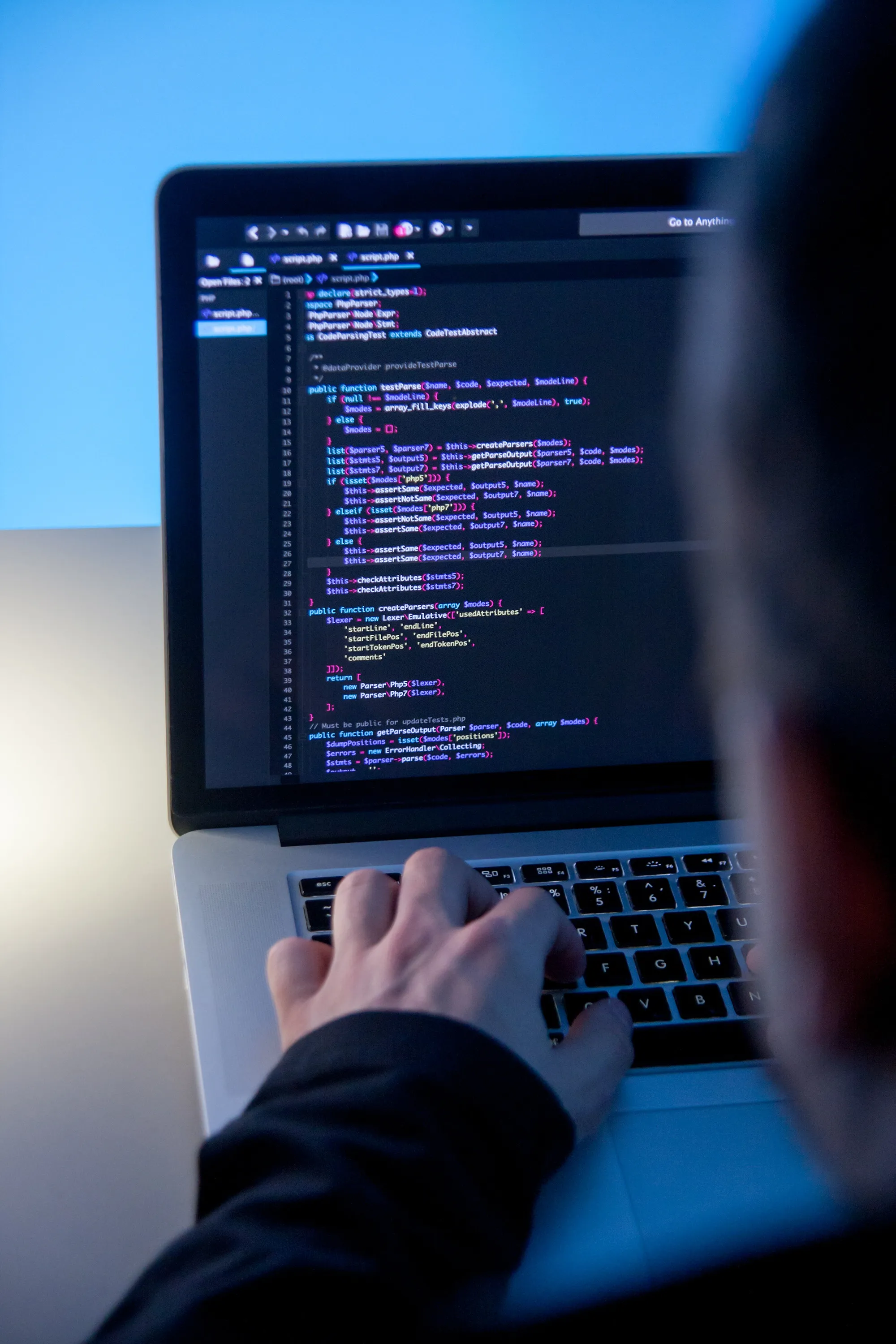 Developer writing code on a laptop