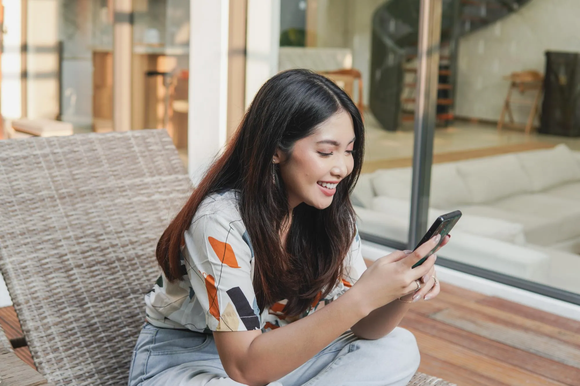 Woman smiling while browsing a website on her smartphone